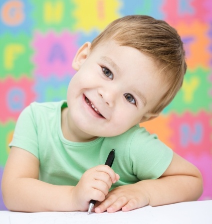 16336148 - cute little girl is writing using a pen in preschool